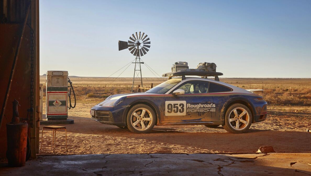 Porsche 911 Dakar im Rallye-Design in der Seitenansicht vor einer Wüstenlandschaft