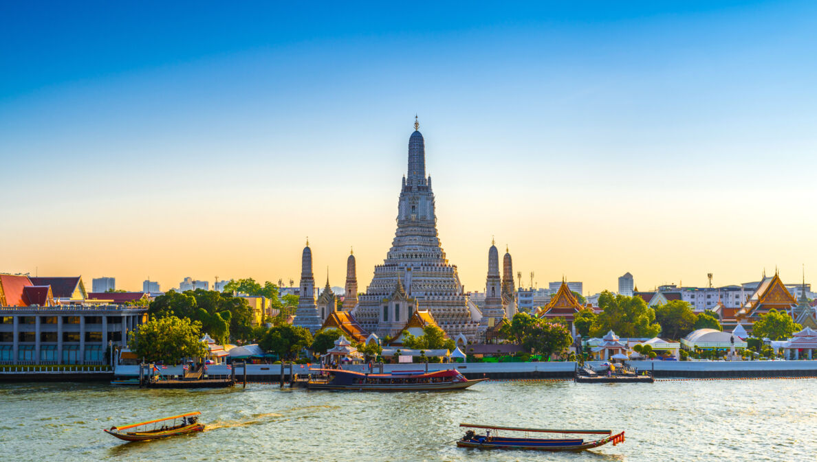 Blick vom Wasser auf den Arun Tempel in Bangkok in der Morgendämmerung