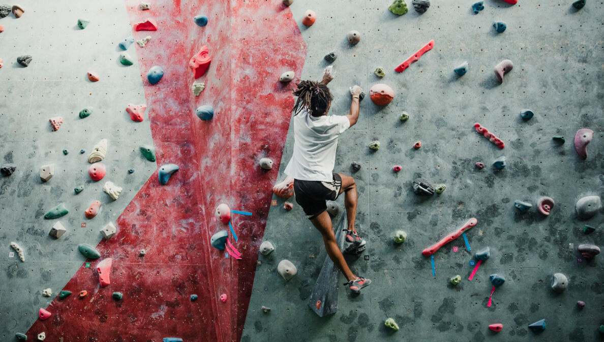 Eine Person bouldert in einem Kletterzentrum