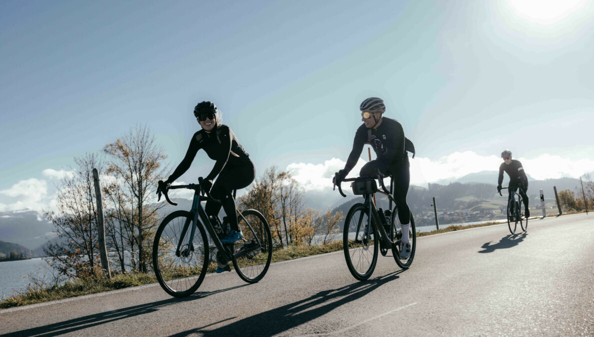 Mehrere Radfahrende auf einer Straße bei Sonnenschein