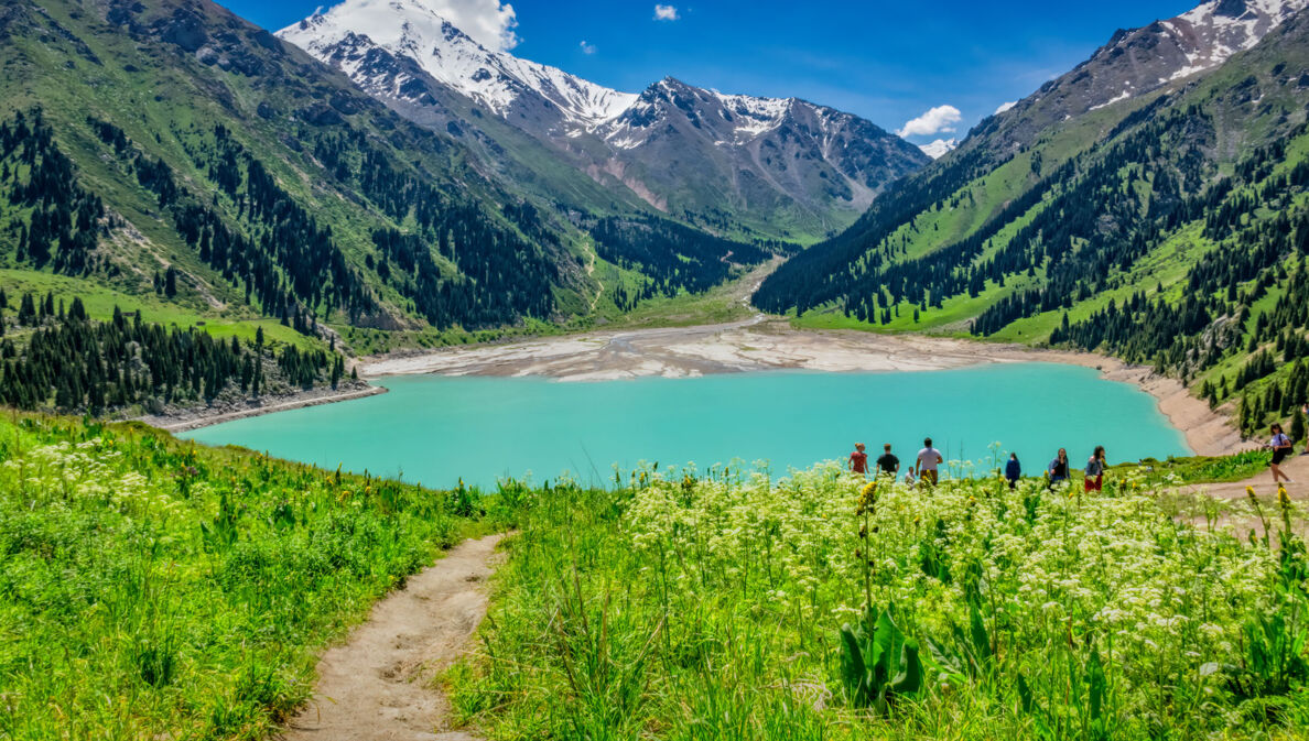 Blick auf den Almaty See in Kasachstan, der in ein Gebirge gebettet ist.