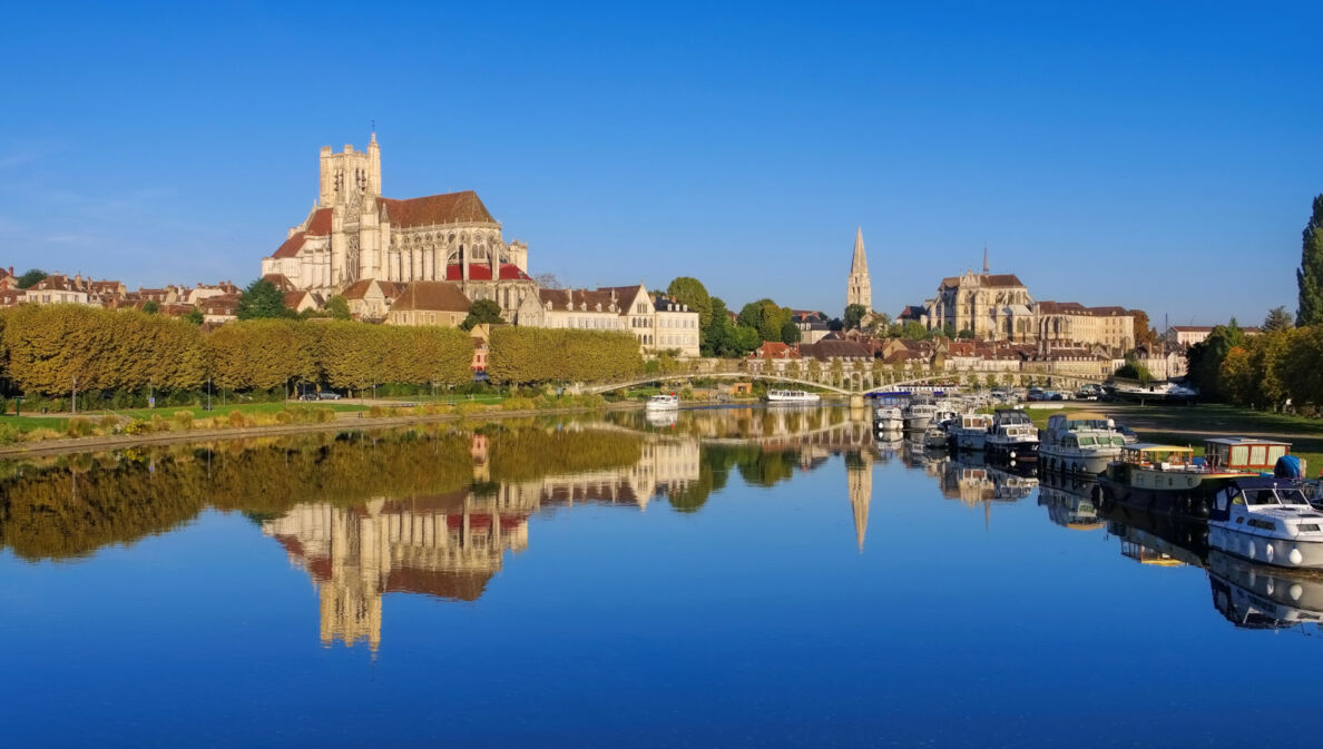 Stadtpanorma von Auxerre mit Kathedrale und Abtei, davor Boote auf einem Fluss