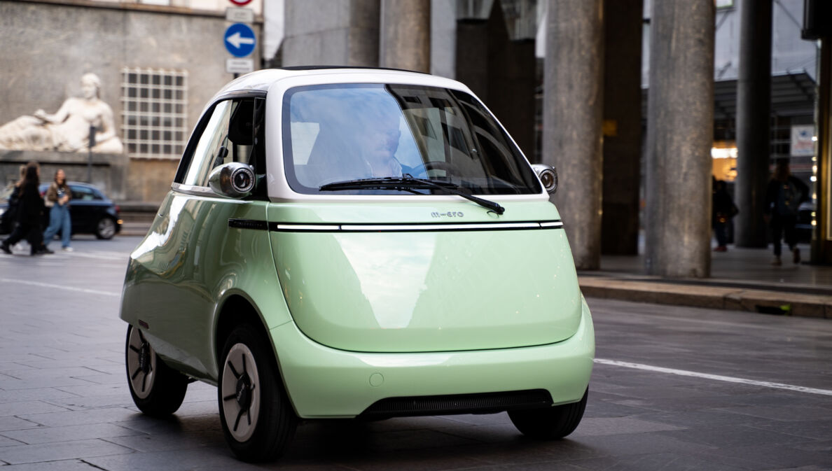 Mintfarbenes Elektrokleinfahrzeug auf einer Straße