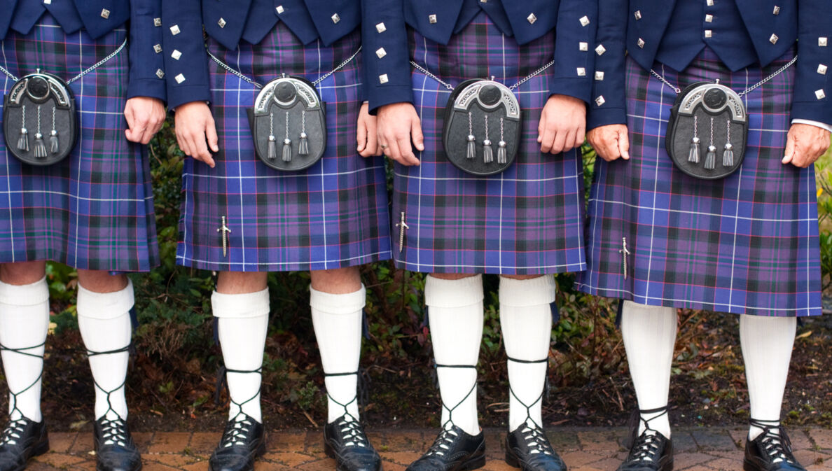 Unterkörper von stehenden Menschen in blauen Kilts