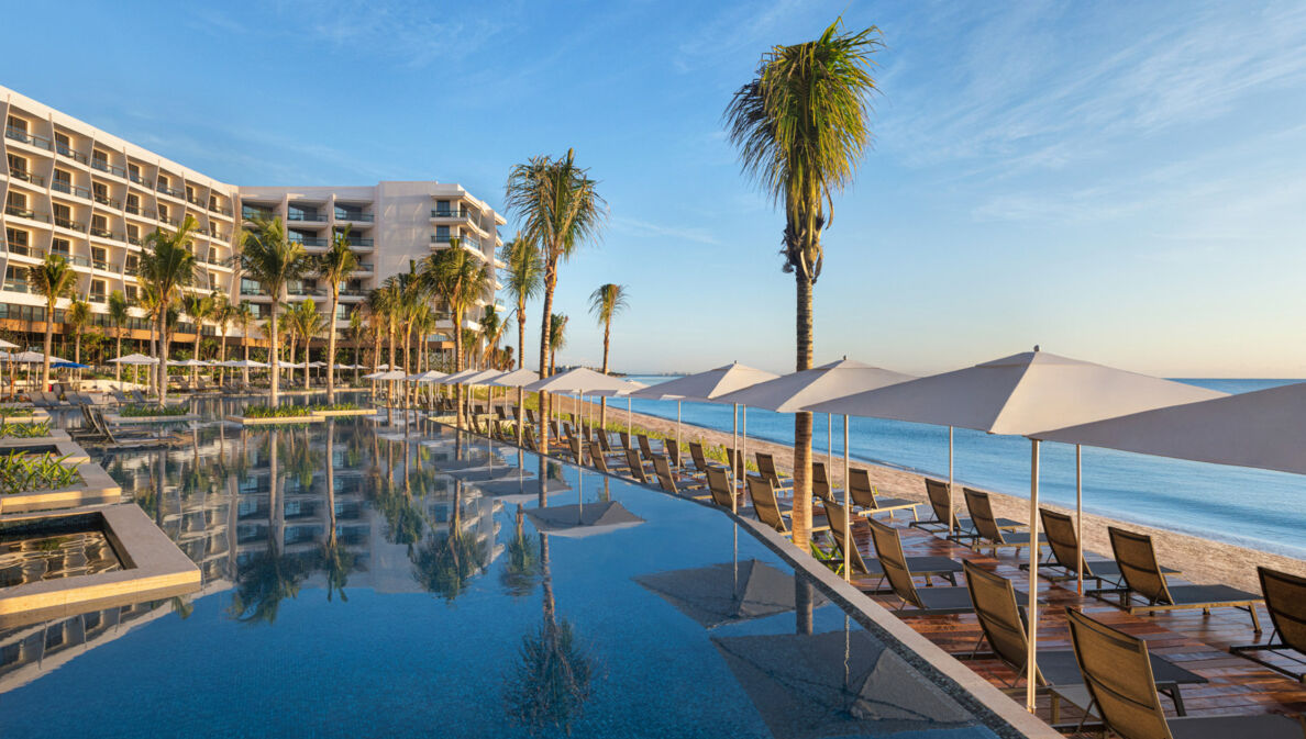 Eine Hilton Hotelanlage mit Pool an einem Sandstrand