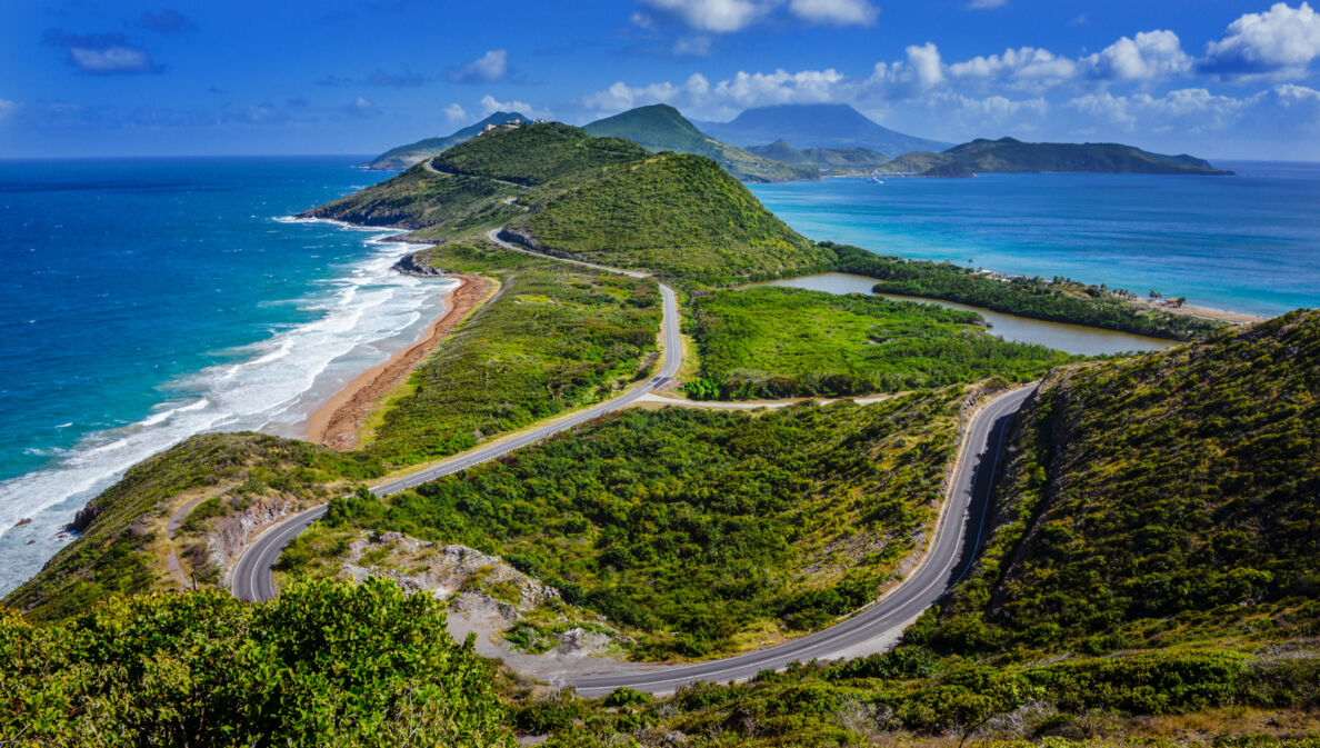 Aufnahme über die Landschaft und Küste der Insel St. Kitts mit der Insel Nevis im Hintergrund.