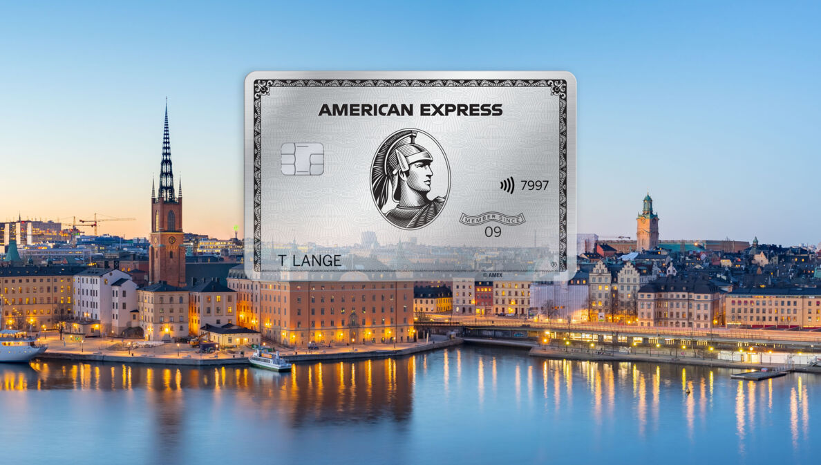 Freisteller einer Platinum Card von American Express vor der abendlich erleuchteten Skyline von Stockholm.