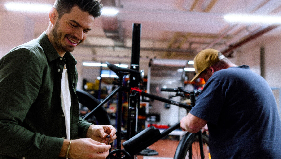 Andy Weinzierl und ein Mitarbeiter montieren ein Sushi-Bike