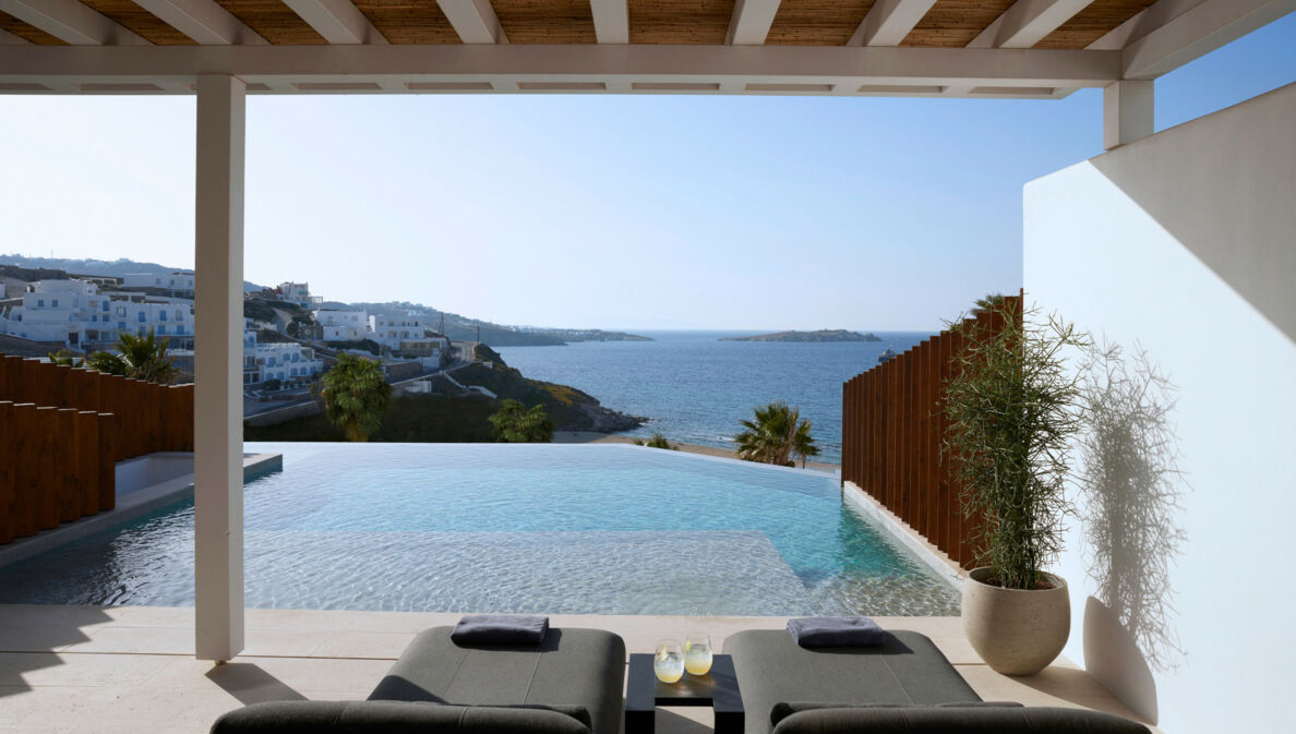 Terrasse mit Liegen und Infinitypool mit Meerblick an einem Küstenort.