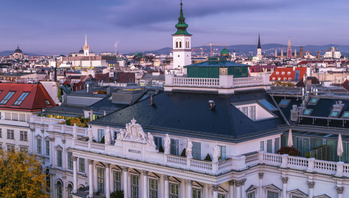 Spätklassizistische Fassade und Dach des Palais Coburg vor der Skyline Wiens.