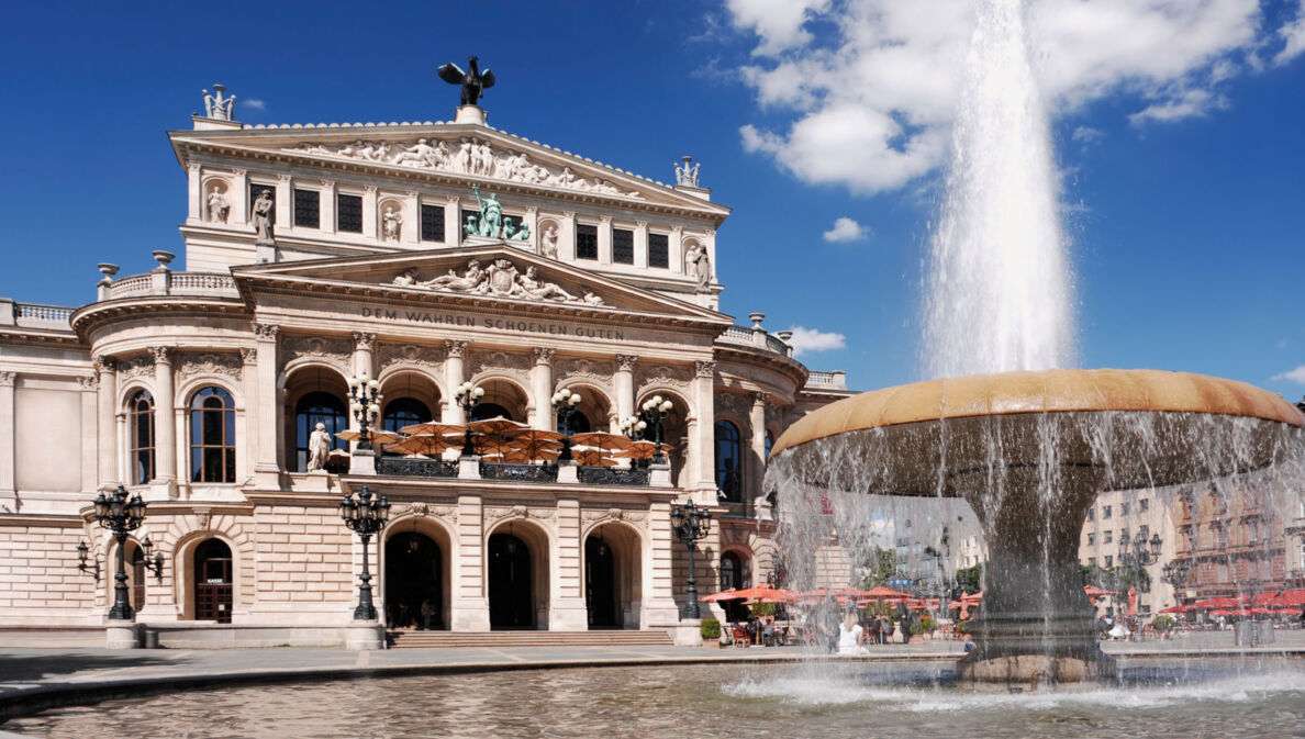 Prachtvolles Operngebäude im Stil der Neorenaissance mit Restaurant, im Vordergrund ein Springbrunnen.