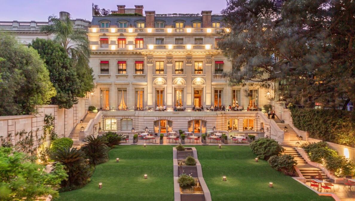 Außenansicht der Fassade und Gärten des Luxushotels Palacio Duhau in Buenos Aires bei Dämmerung.