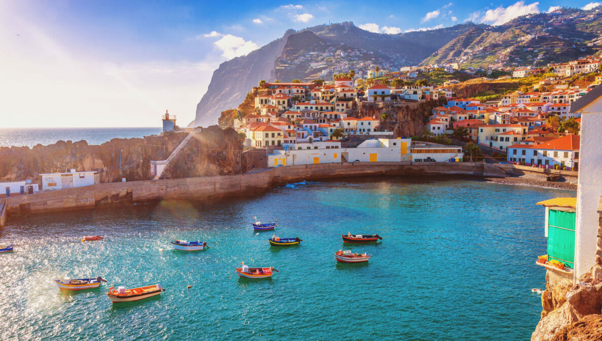 Panorama von Funchal auf Madeira mit Booten im Vordergrund und Bergen im Hintergrund.