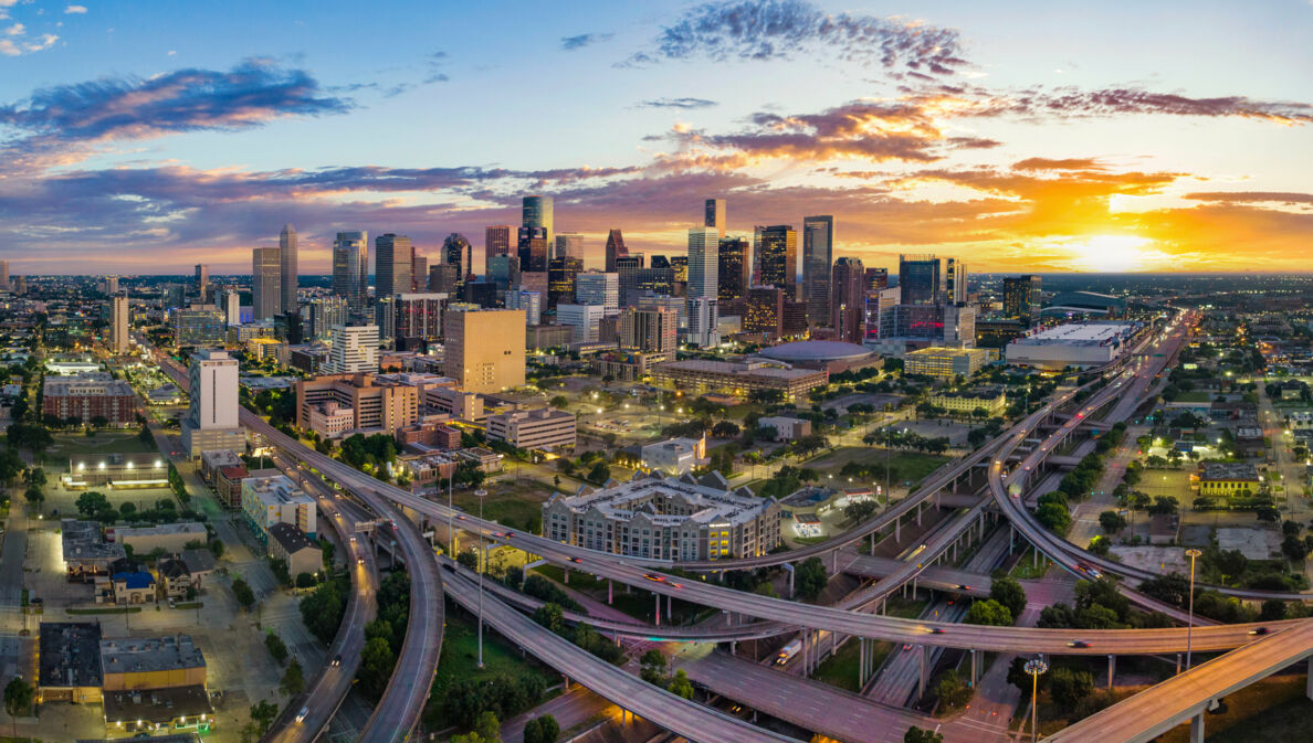 Skyline von Houston mit Autobahnkreuz bei Sonnenuntergang.