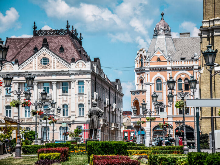 Blick auf eine gepflegte Grünanlage mit schöner Architektur im Hintergrund