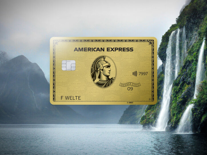 Fotocollage mit einer goldenen Kreditkarte von American Express vor einer nebeligen Berglandschaft an einem See mit Wasserfall.