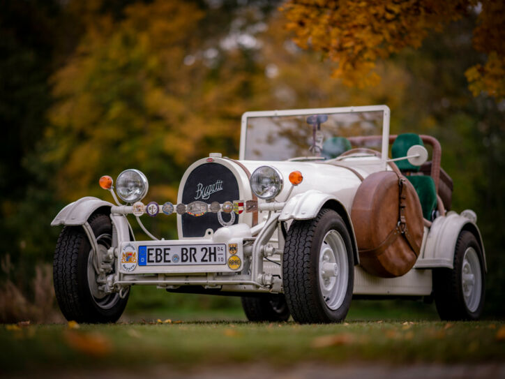 Weißer Bugatti Cabriolet Oldtimer mit H-Kennzeichen in einem Park.