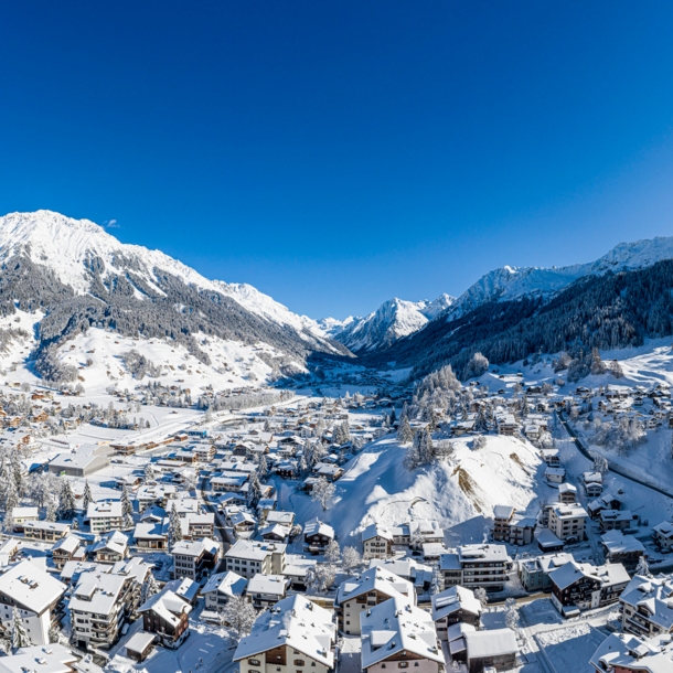 Blick auf die verschneite und im Tal liegende Ortschaft Klosters