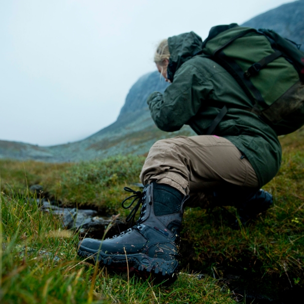 Frau mit Wanderschuhen in regnerischer Berglandschaft