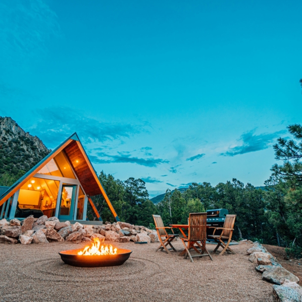 Tiny House mit kleiner Feuerstelle am Abend