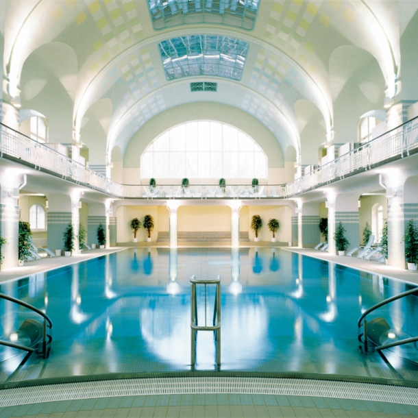 Großes Schwimmbecken in einer im Jugendstil erbauten Badeanstalt mit weißem Kuppeldach