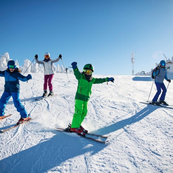 Eine Familie fährt gemeinsam Ski auf der Piste