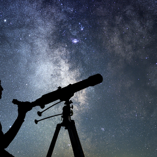 Eine Frau mit Teleskop vor Sternenhimmel.