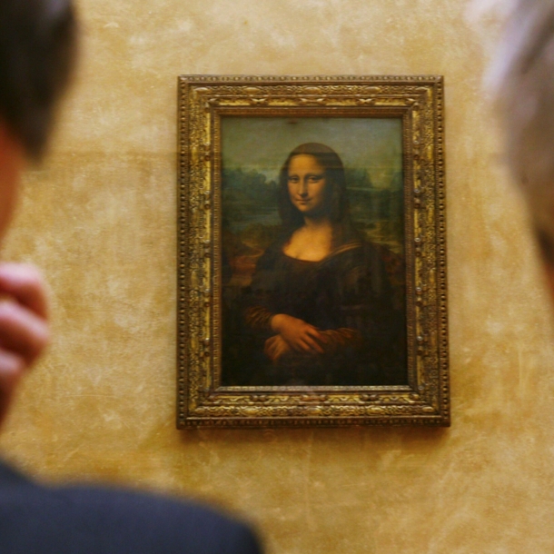 Das Gemälde der Mona Lisa an der Wand zwischen zwei Betrachtern