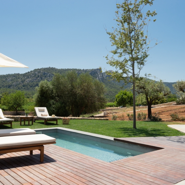 Ein kleiner Pool und Sonnenliegen vor einer bergigen Landschaft