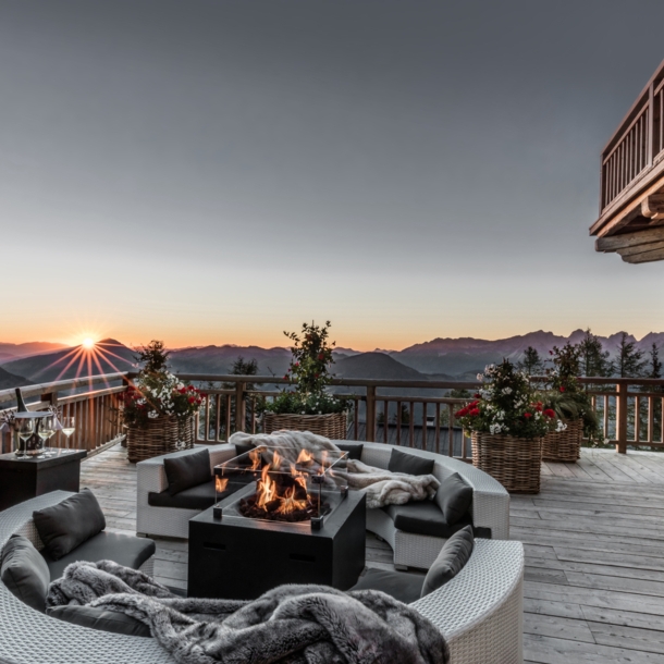 Eine Terrasse mit Feuerstelle und Blick über die Alpen