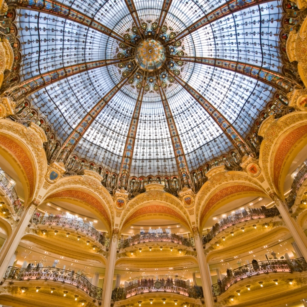 Zentrale, runde Halle des Pariser Kaufhauses Galeries Lafayette mit Balkonen und imposanter Glaskuppel in Jugendstilarchitektur