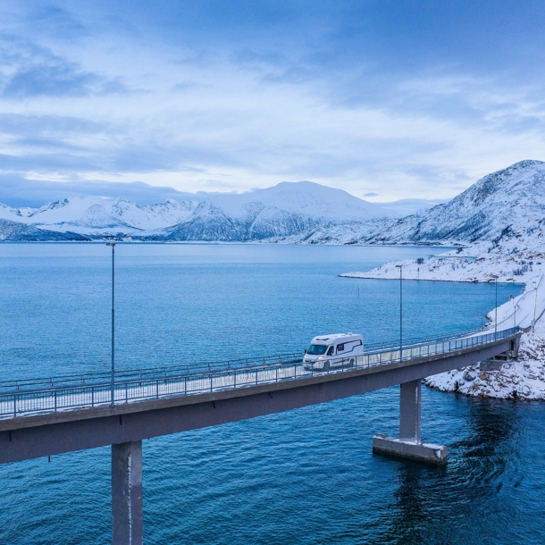 Luftaufnahme einer Brücke an einer Küste mit einem Wohnmobil