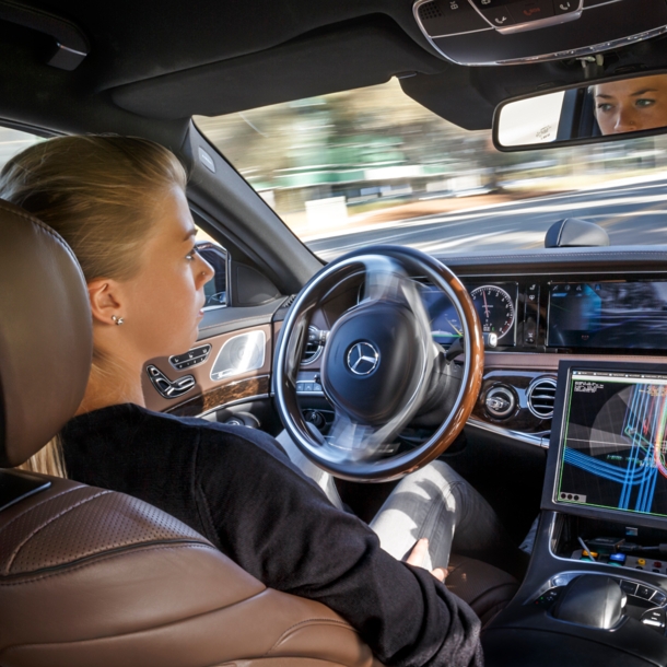 Blick in das Cockpit eines Pkw. Die Hände der Fahrerin sind nicht am Lenkrad