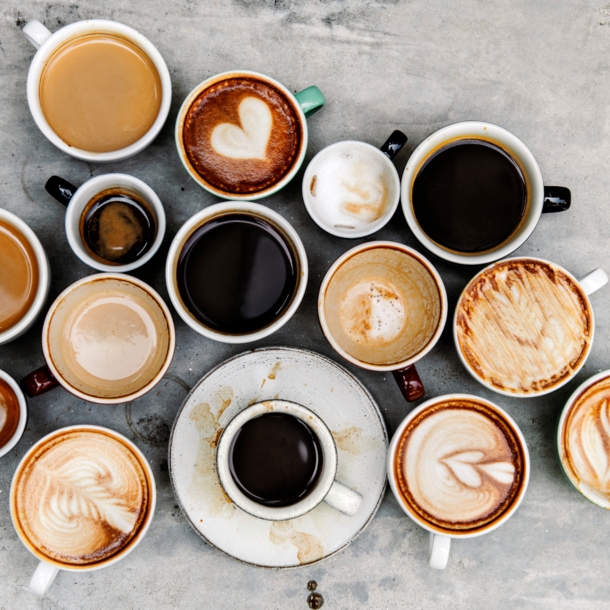 Verschiedene Kaffeespezialitäten auf einem Tisch von oben fotografiert