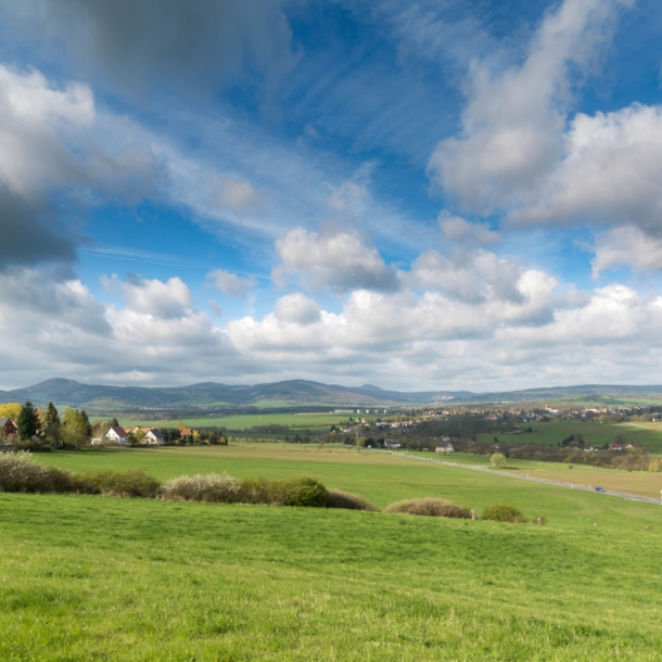 Blick auf eine sommerliche Landschaft mit Wiesen und Bergen