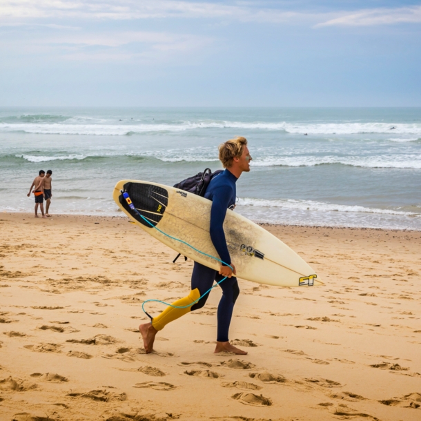 Ein Surfer mit Surfbrett an einem Strand