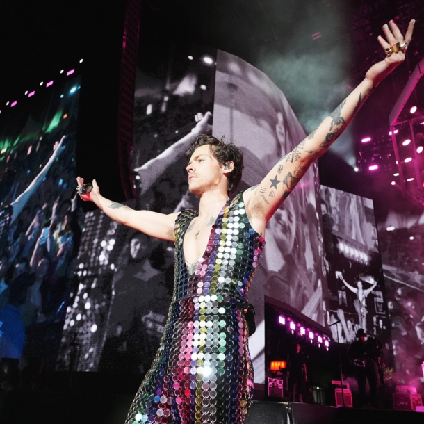 Sänger Harry Styles in einem glitzernden Paillettenanzug auf einer Bühne