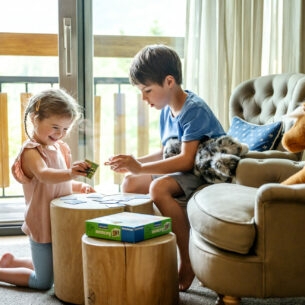 Zwei Kinder spielen in einem Hotelzimmer Memory