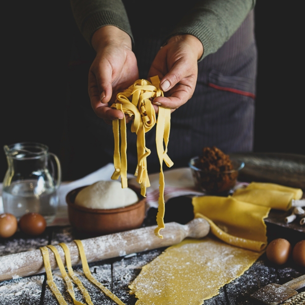 Eine Person hält selbstgemachte Pasta in die Kamera