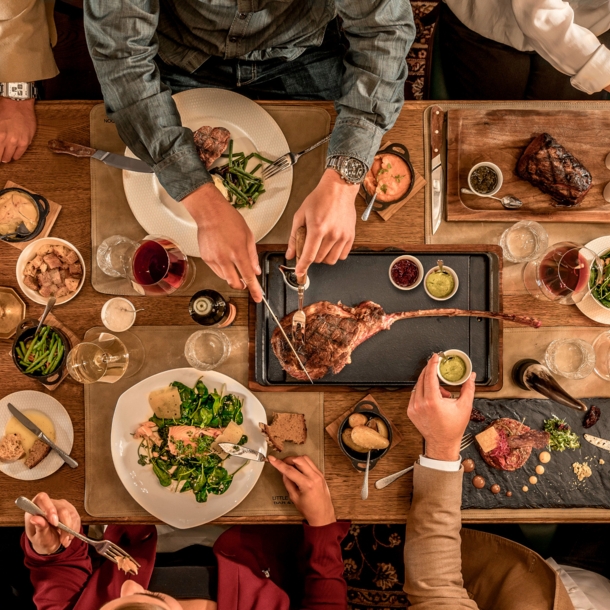 Top-Shot auf einen üppig gedeckten Tisch, an dem mehrere Personen sitzen und essen.