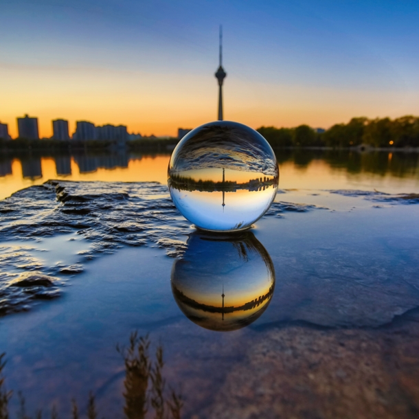 Skyline einer Stadt durch eine Glaskugel im Sonnenuntergang fotografiert