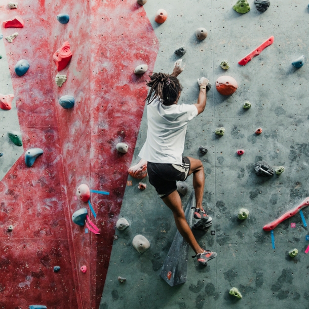 Eine Person bouldert in einem Kletterzentrum