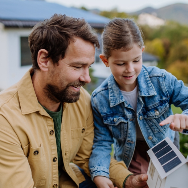 Vater und Tochter mit dem Modell eines Hauses