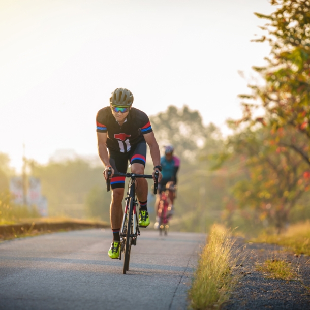 Zwei Rennradfahrer auf einer Straße im Abendlicht