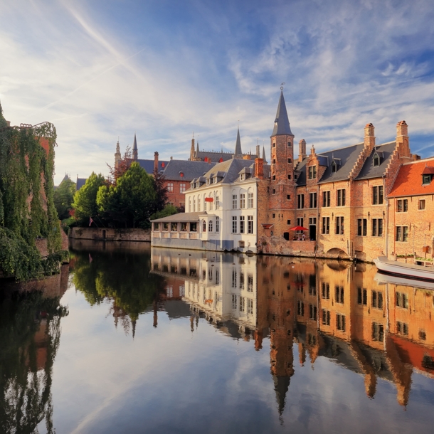 Historisches Zentrum von Brügge mit mittelalterlichen Gebäuden, die sich im Wasser spiegeln.