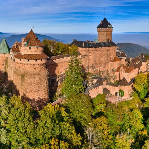 Panoramaaufnahme der mittelalterlichen Hohkönigsburg auf einem bewaldeten Hügel im Elsass