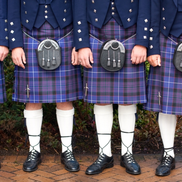 Unterkörper von stehenden Menschen in blauen Kilts