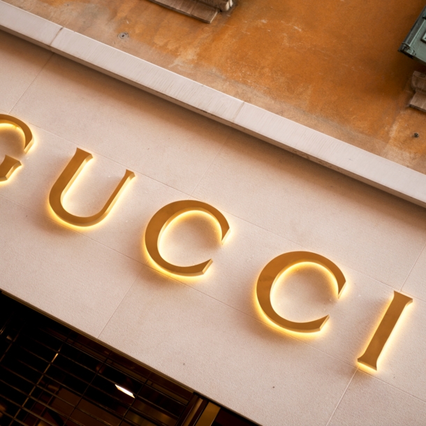 Das Logo von Gucci in Goldlettern an einer mediterranen Hausfassade