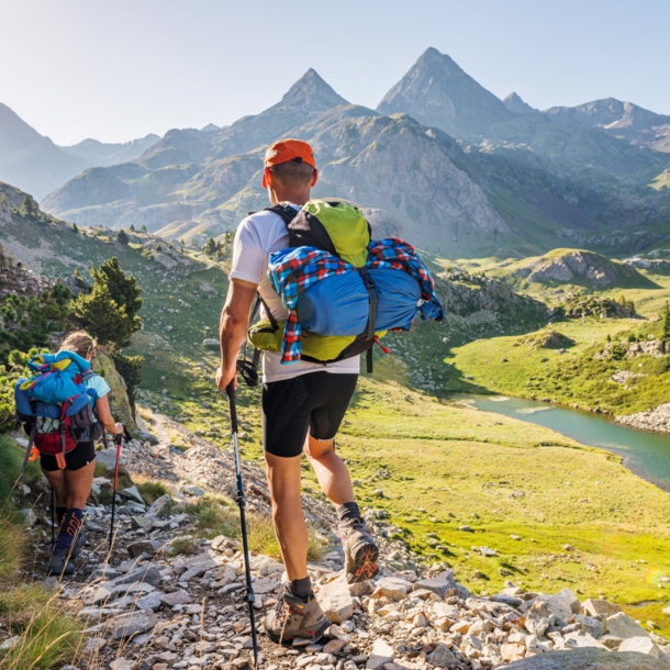 Rückansicht von zwei Wandernden mit Rucksäcken vor Bergpanorama in den Pyrenäen