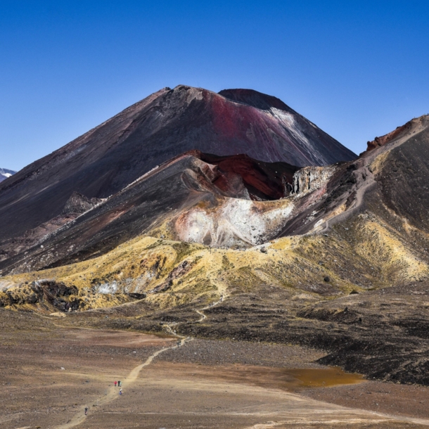 Ein dunkler Vulkan mit roten Farbverläufen in karger Landschaft